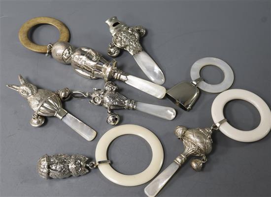 Seven assorted early 20th century and later silver childs rattles with teethers, including owl and rabbit.